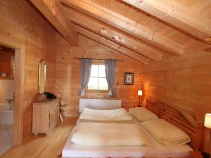 a bedroom with a bed in a wooden cabin at Chalet Königsleiten 2 by Interhome in Königsleiten