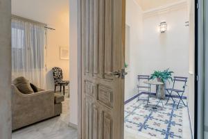 una porta che conduce a un soggiorno con divano e tavolo di Hércules XCI Apartments a Siviglia