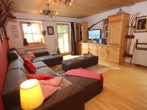 a living room with a couch and a tv at Chalet Königsleiten 2 by Interhome in Königsleiten