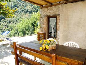 einen Holztisch mit Blumen auf der Terrasse in der Unterkunft Holiday Home Castagneto by Interhome in Loppeglia