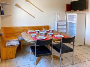 una cucina con un tavolo con due sedie e un frigorifero di Apartment Arn's Place by Interhome a Wangenried  