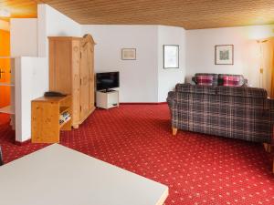 ein Wohnzimmer mit einem Sofa und einem TV in der Unterkunft Apartment Chalet Abendrot-13 by Interhome in Grindelwald