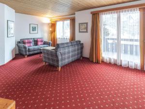 uma sala de estar com duas cadeiras e um sofá em Apartment Chalet Abendrot-13 by Interhome em Grindelwald
