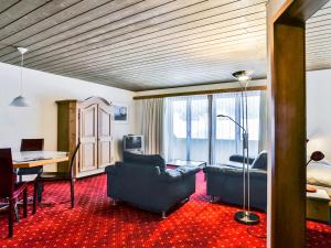 ein Wohnzimmer mit einem Sofa und einem Schreibtisch in einem Zimmer in der Unterkunft Apartment Chalet Abendrot-15 by Interhome in Grindelwald