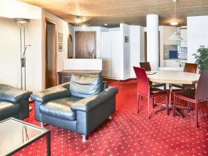 ein Wohnzimmer mit einem Sofa, einem Tisch und Stühlen in der Unterkunft Apartment Chalet Abendrot-15 by Interhome in Grindelwald