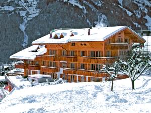 um grande edifício de madeira na neve com neve em Apartment Chalet Abendrot apARTments-2 by Interhome em Grindelwald