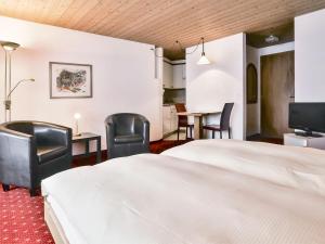 um quarto de hotel com uma cama e cadeiras e uma mesa em Apartment Chalet Abendrot-7 by Interhome em Grindelwald