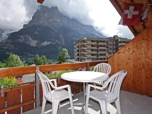 a white table and chairs on a balcony with a mountain at Apartment Chalet Abendrot apARTments-23 by Interhome in Grindelwald
