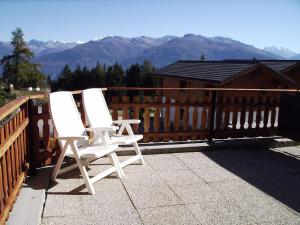 アンゼールにあるApartment Les Rocailles by Interhomeの山々を背景にデッキに座る白い椅子2脚