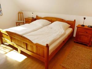 ノルデンにあるHoliday Home Richtpfad by Interhomeのテーブルと椅子が備わる客室の木製ベッド1台分です。