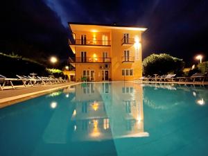 a swimming pool in front of a building at night at Residence Beatrix in Bardolino