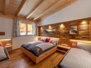 Duas camas num quarto com paredes de madeira em Apartment Chalet Spatn by Interhome em Fügenberg