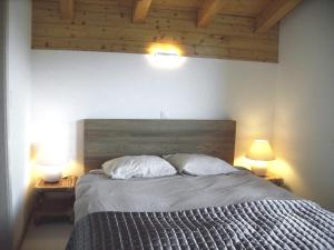 a bedroom with a bed with two pillows and two lamps at Chalet Annabel by Interhome in Anzère