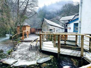 a wooden deck with a chair next to a house at Riverside Cottage in Barnstaple