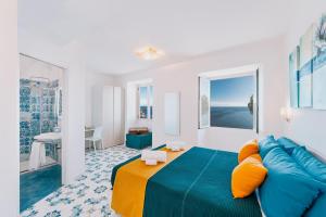 a bedroom with a blue bed and a blue couch at Villa Eris Amalfi Coast in Conca dei Marini