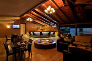 a living room with tables and chairs and a bar at Vienna City Hotel in Tema