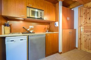 eine Küche mit einer Spüle und einer Mikrowelle in der Unterkunft Preciosa Pleta en la Vall d’Incles HUT 7960 in Canillo
