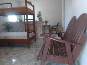 a room with a bunk bed and a rocking chair at Hostel Viajante Marajo in Soure