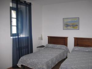 a bedroom with two beds and a window at GITE DES FRANCISCAINS-Imiza in Canari
