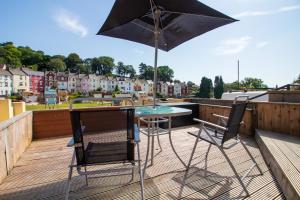a patio with a table and chairs and an umbrella at Stylish Studio in the Heart of the English Riviera in Torquay