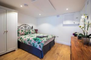 a bedroom with a bed with a floral bedspread at Stylish Studio in the Heart of the English Riviera in Torquay