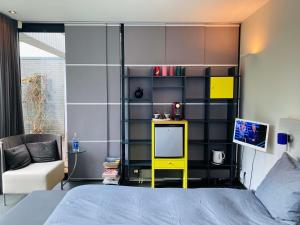 a bedroom with a bed with a yellow shelf at B&B Winterresidentie in Tilburg
