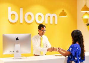 a man and a woman shaking hands in front of an apple computer at Bloom Hotel - Juhu in Mumbai