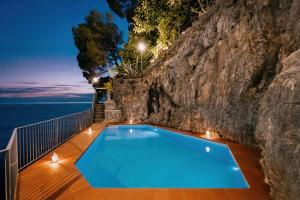 ein Pool vor einer Felswand in der Unterkunft Villa Eris Amalfi Coast in Conca dei Marini