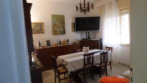a dining room with a table and a tv at Al 12 in Marina di Pisa