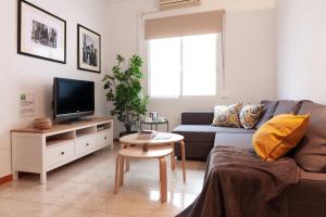 a living room with a couch and a tv at SW Soho Family Apartment in Málaga