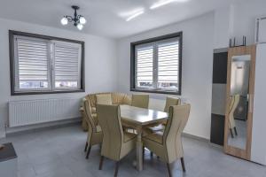- une salle à manger avec une table, des chaises et des fenêtres dans l'établissement Pensiunea RAVHOUSE, à Vadu Izei