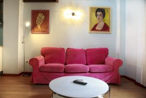 sala de estar con sofá rosa y mesa en La Casita de Hinestrosa, en Málaga