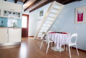 cocina y comedor con mesa y escalera en La Casita de Hinestrosa, en Málaga