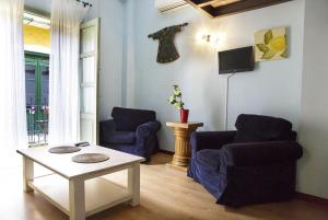 sala de estar con 2 sillas y mesa en La Casita de Hinestrosa, en Málaga