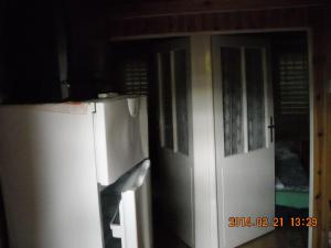 Il comprend une cuisine dotée d'une porte blanche et d'un réfrigérateur. dans l'établissement Demeter Apartman, à Hajdúszoboszló