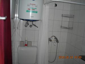 La salle de bains est pourvue d'une douche et de toilettes avec un réservoir d'eau. dans l'établissement Demeter Apartman, à Hajdúszoboszló