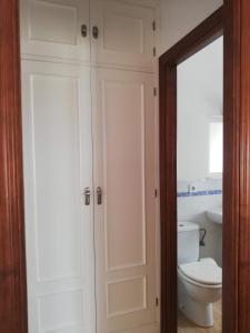 łazienka z białymi szafkami i toaletą w obiekcie Miramar Conil w mieście Conil de la Frontera