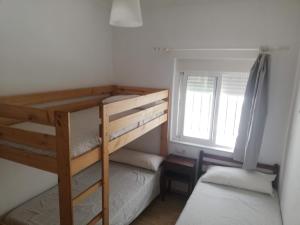 sypialnia z dwoma łóżkami piętrowymi i oknem w obiekcie Miramar Conil w mieście Conil de la Frontera