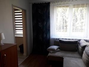 uma sala de estar com um sofá e uma grande janela em Danusia em Klodzko
