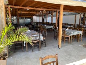 um restaurante com mesas e cadeiras e mesas e cadeiras em Myrodato Rooms em Xanthi