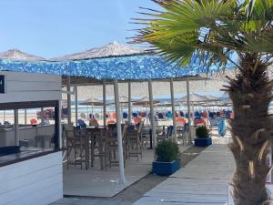 a patio with tables and chairs and umbrellas on the beach at Myrodato Rooms in Xanthi