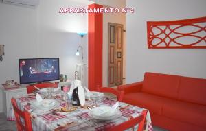 sala de estar con mesa y sofá rojo en Red & Blu Apartments, en Desenzano del Garda