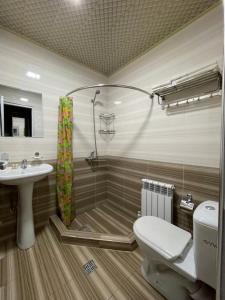 a bathroom with a shower and a toilet and a sink at Hotel Ishonch in Samarkand
