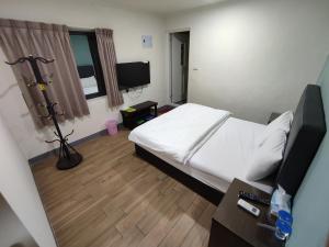 Juguangにある莒光英雄館民宿 B&bのベッドとテレビが備わるホテルルームです。