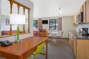 a room with a kitchen and a desk with a table at Super 8 by Wyndham South Boston VA in South Boston