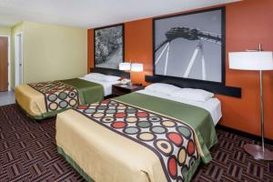 a hotel room with two beds and a painting on the wall at Super 8 by Wyndham Rochester in Rochester