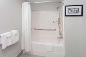 a white bathroom with a shower and a bath tub at Super 8 by Wyndham Rochester in Rochester
