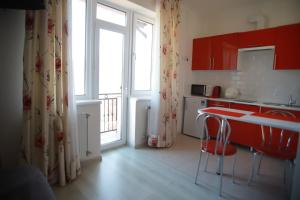 a kitchen with red cabinets and a red counter top at Апартаменти Сонячне in Polyana