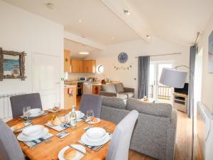 een keuken en een woonkamer met een tafel en een bank bij Beside the Sea in Bridport