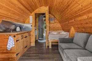 un soggiorno con divano e un letto in una cabina di Pods at Broadway a Laugharne